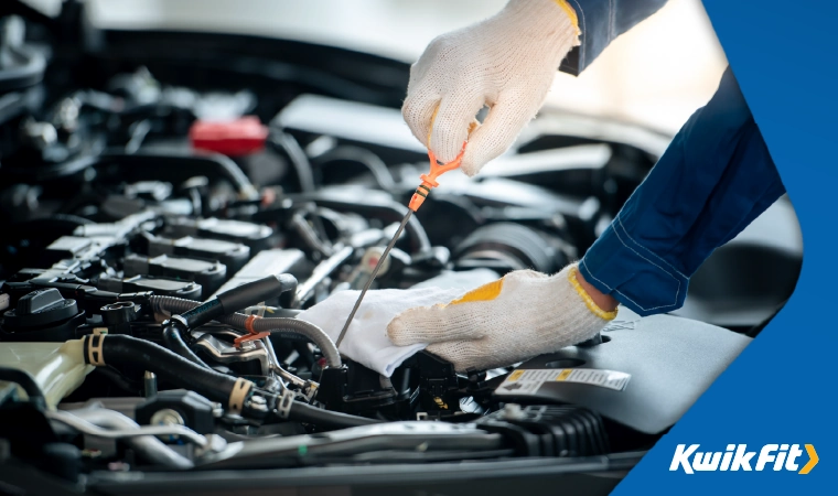 mechanic checking engine oil level
